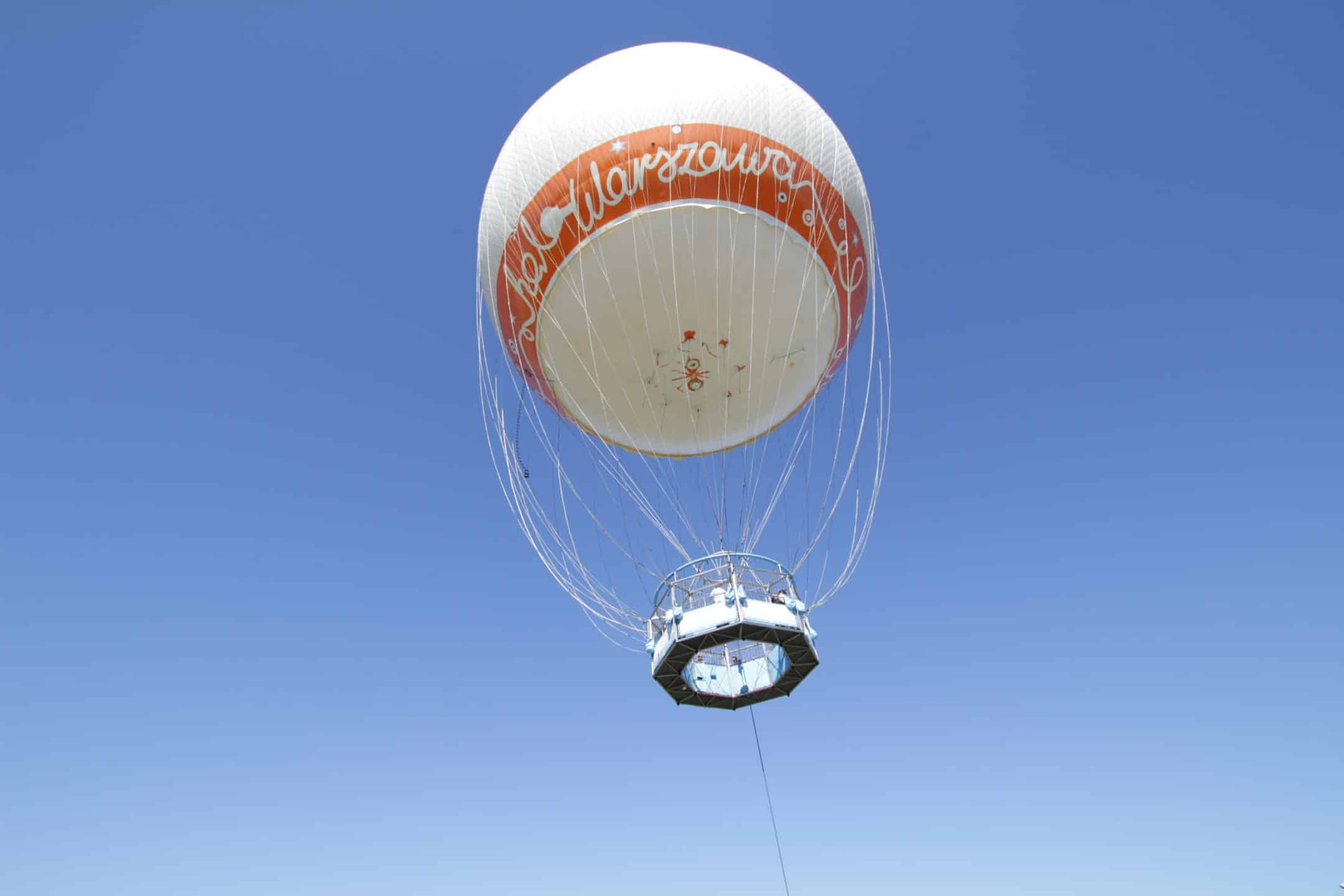 Balon do latania z koszem dla ludzi na tle nieba.